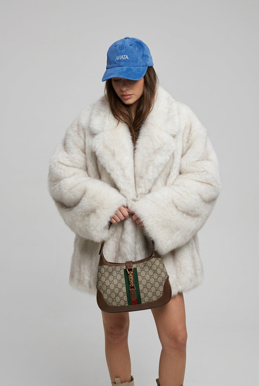 Detail of the plush faux fur surface on the creamy-white coat