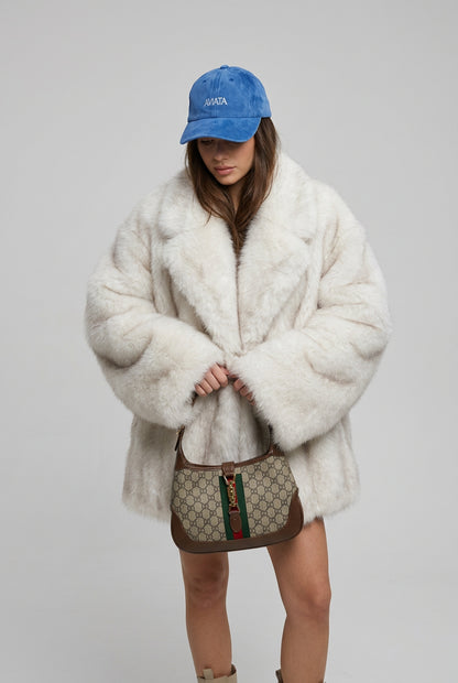 Detail of the plush faux fur surface on the creamy-white coat