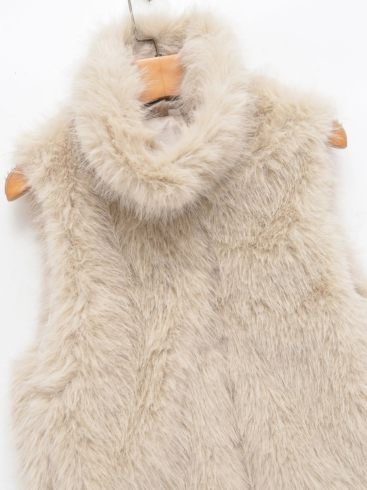 Beige faux fur vest showing its sleeveless silhouette