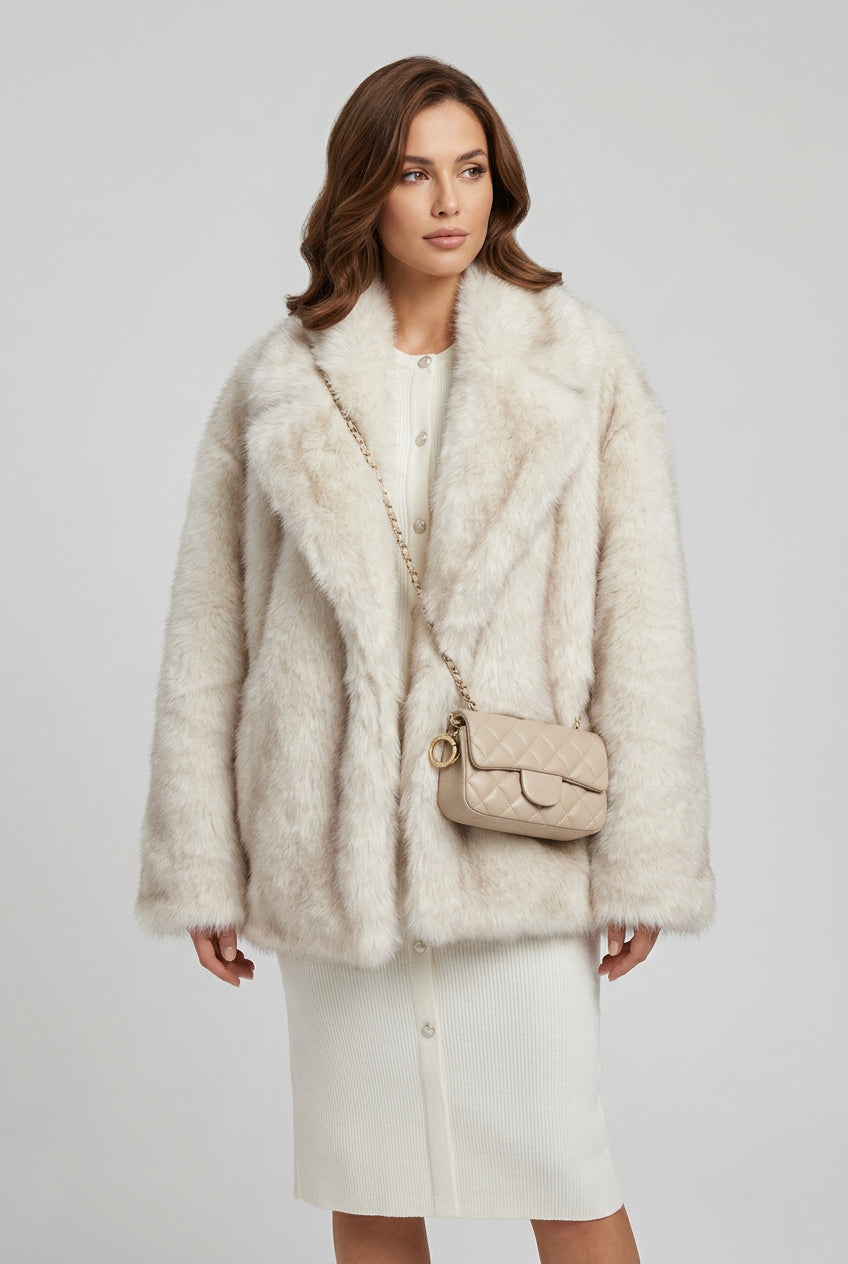 Close view of the plush gradient faux fur texture on a creamy-white coat