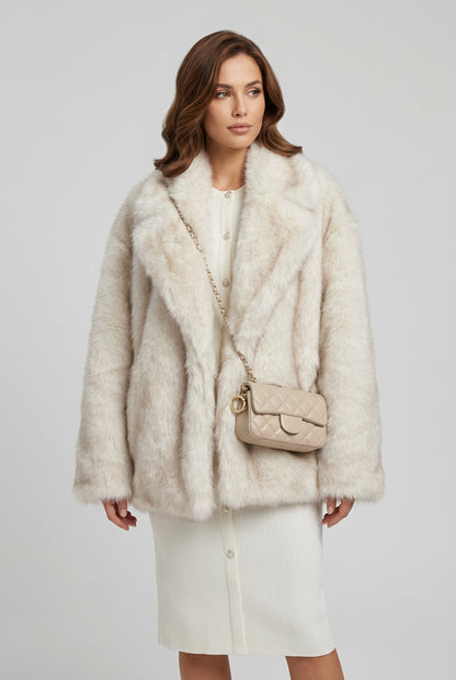 Close view of the plush gradient faux fur texture on a creamy-white coat