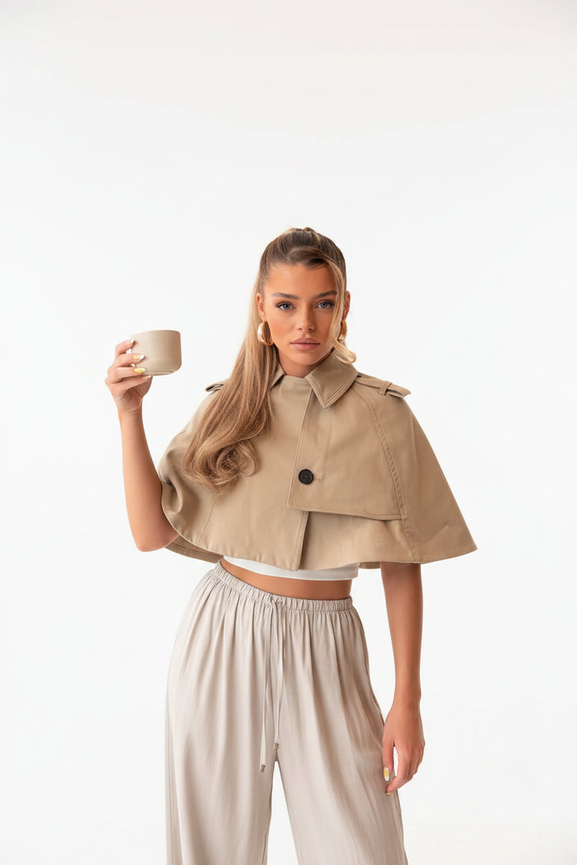 Women's beige cropped coat, double-breasted poncho coat, elegant women's outerwear, chic beige jacket women, luxury women's coat, cropped trench style coat, sophisticated outerwear women, fall fashion coat women, spring layering jacket women, smart casual women's coat, tailored poncho jacket, women's business casual outerwear, fashionable beige coat, designer-inspired women's jacket, modern elegant outerwear, timeless women's coat, luxury neutral coat women, women's transitional jacket.