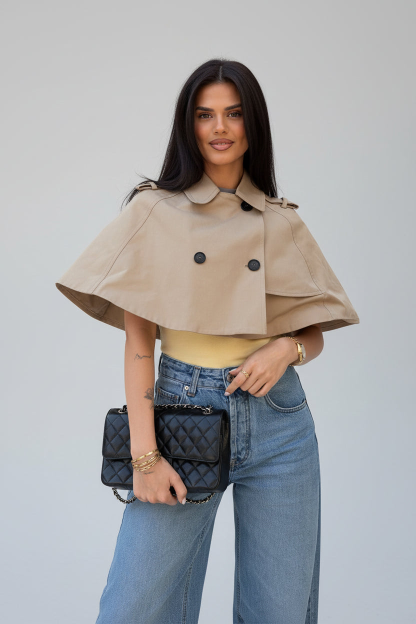 Women's beige cropped coat, double-breasted poncho coat, elegant women's outerwear, chic beige jacket women, luxury women's coat, cropped trench style coat, sophisticated outerwear women, fall fashion coat women, spring layering jacket women, smart casual women's coat, tailored poncho jacket, women's business casual outerwear, fashionable beige coat, designer-inspired women's jacket, modern elegant outerwear, timeless women's coat, luxury neutral coat women, women's transitional jacket.