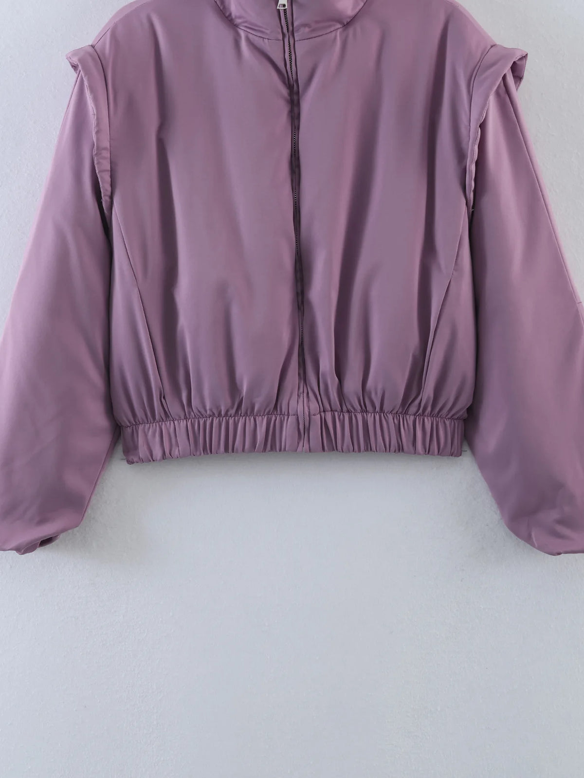 Detail of the glossy satin finish on the cropped bomber jacket
